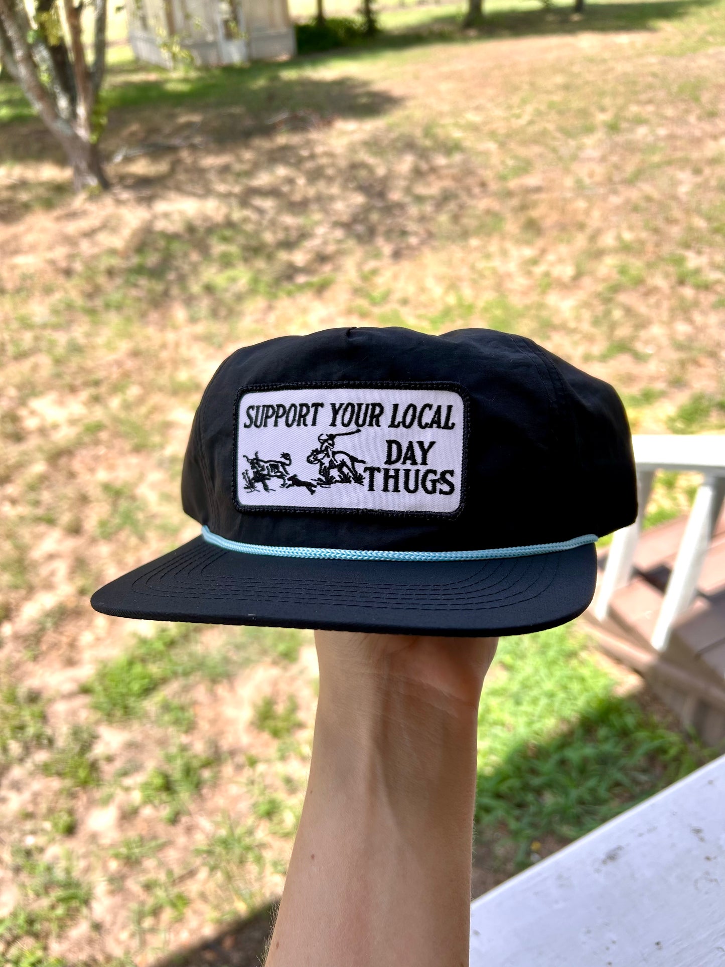 Black snapback with turquoise rope