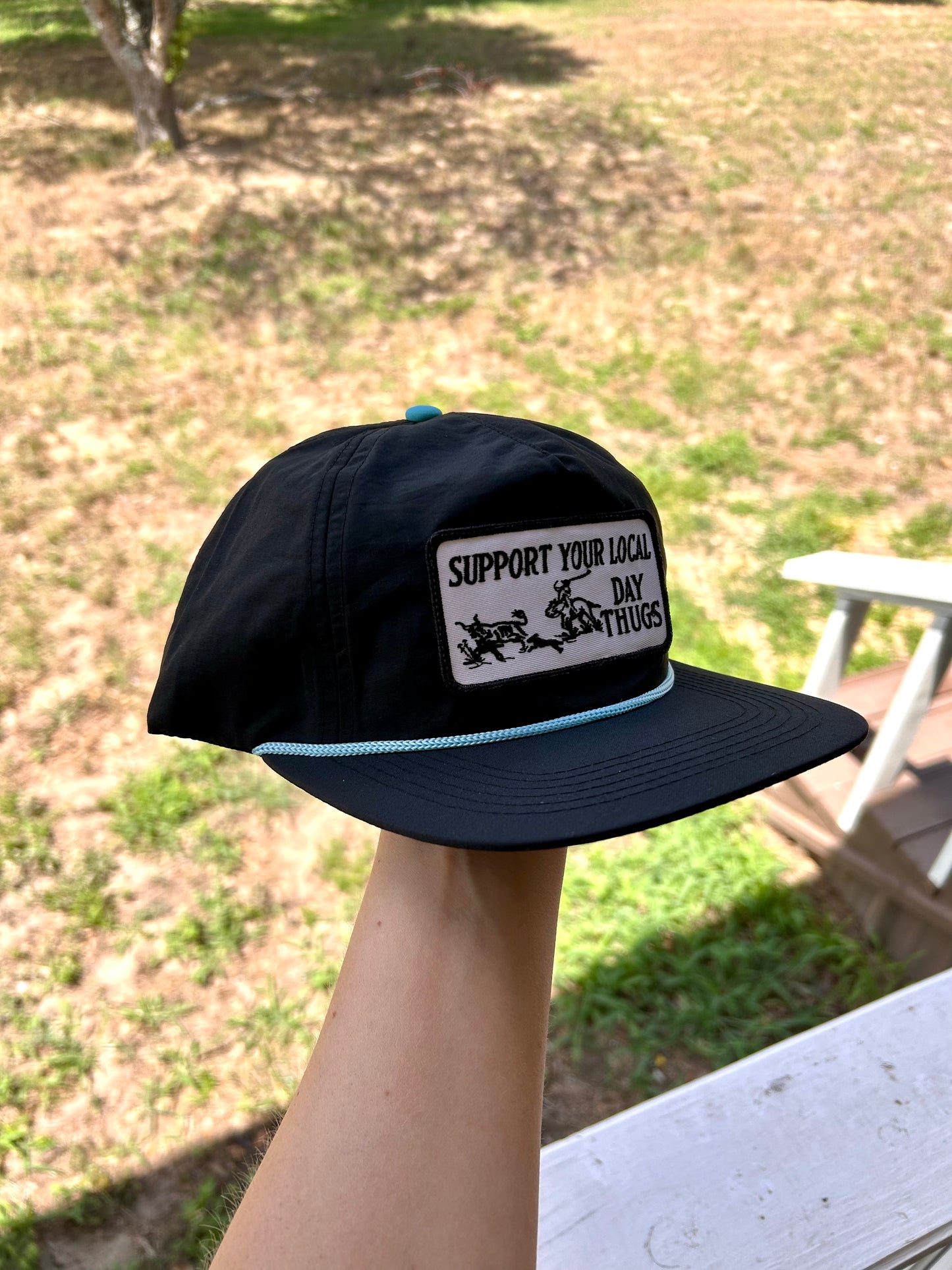 Black snapback with turquoise rope